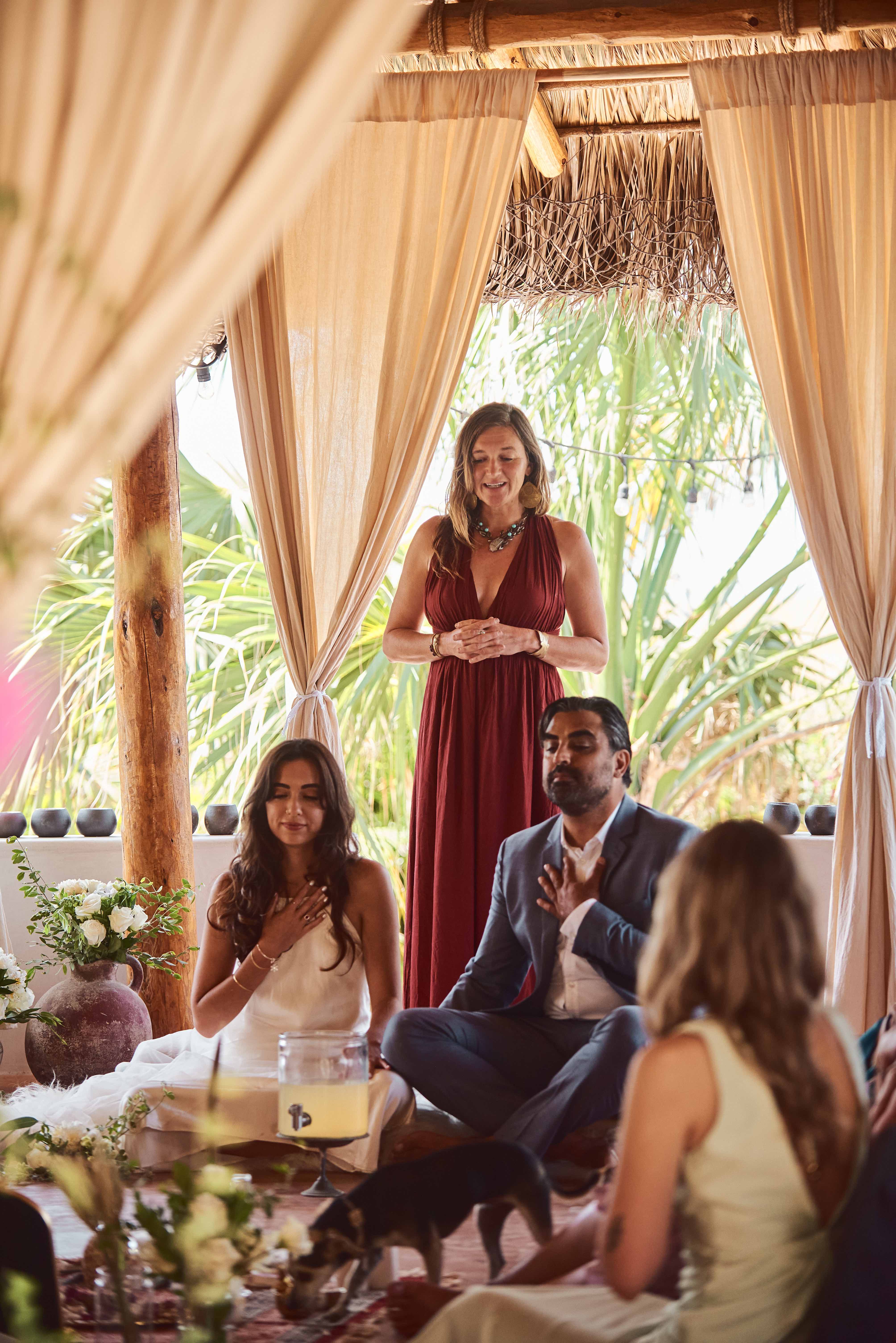 Sacred ceremony gathering in garden palapa with facilitator and couple